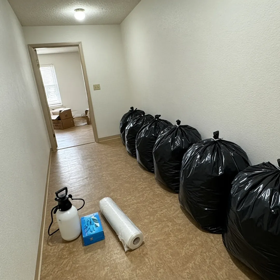 Sealed contractor bags lined up in a hallway during decontamination of a hoarded home